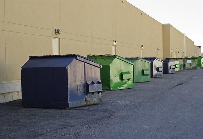 a row of construction dumpsters parked on a jobsite in Astor